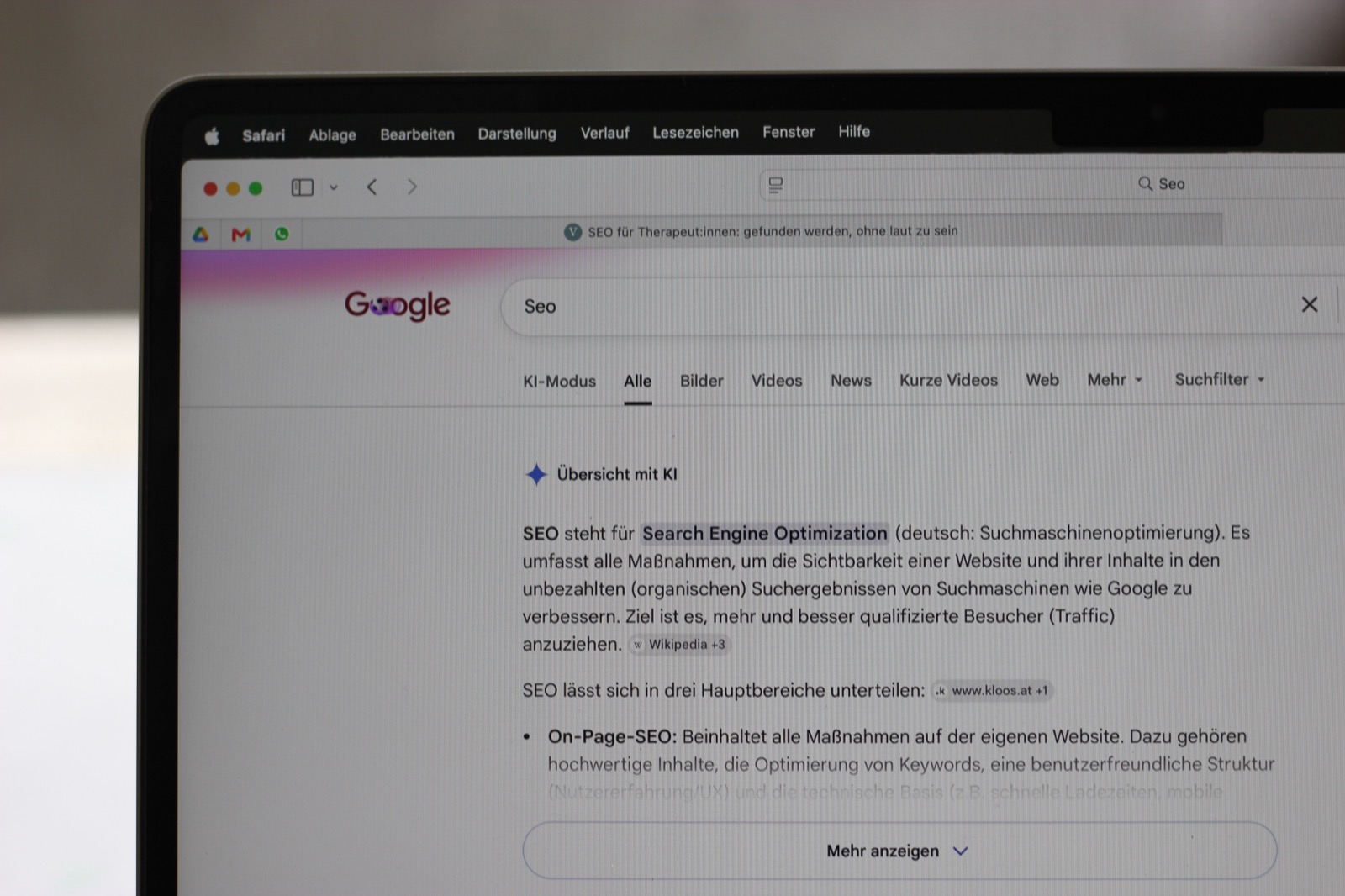 Google-Suche nach SEO mit KI-Übersicht auf einem Laptop