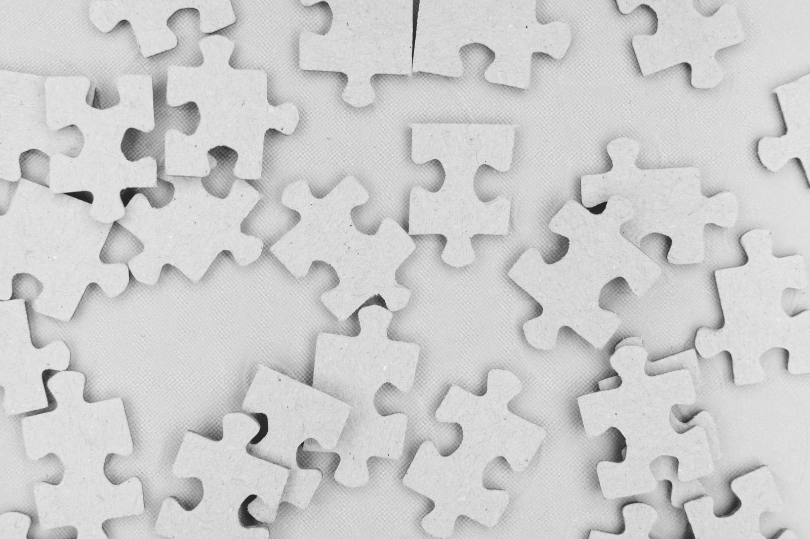 Verstreute Puzzleteile auf hellem Hintergrund